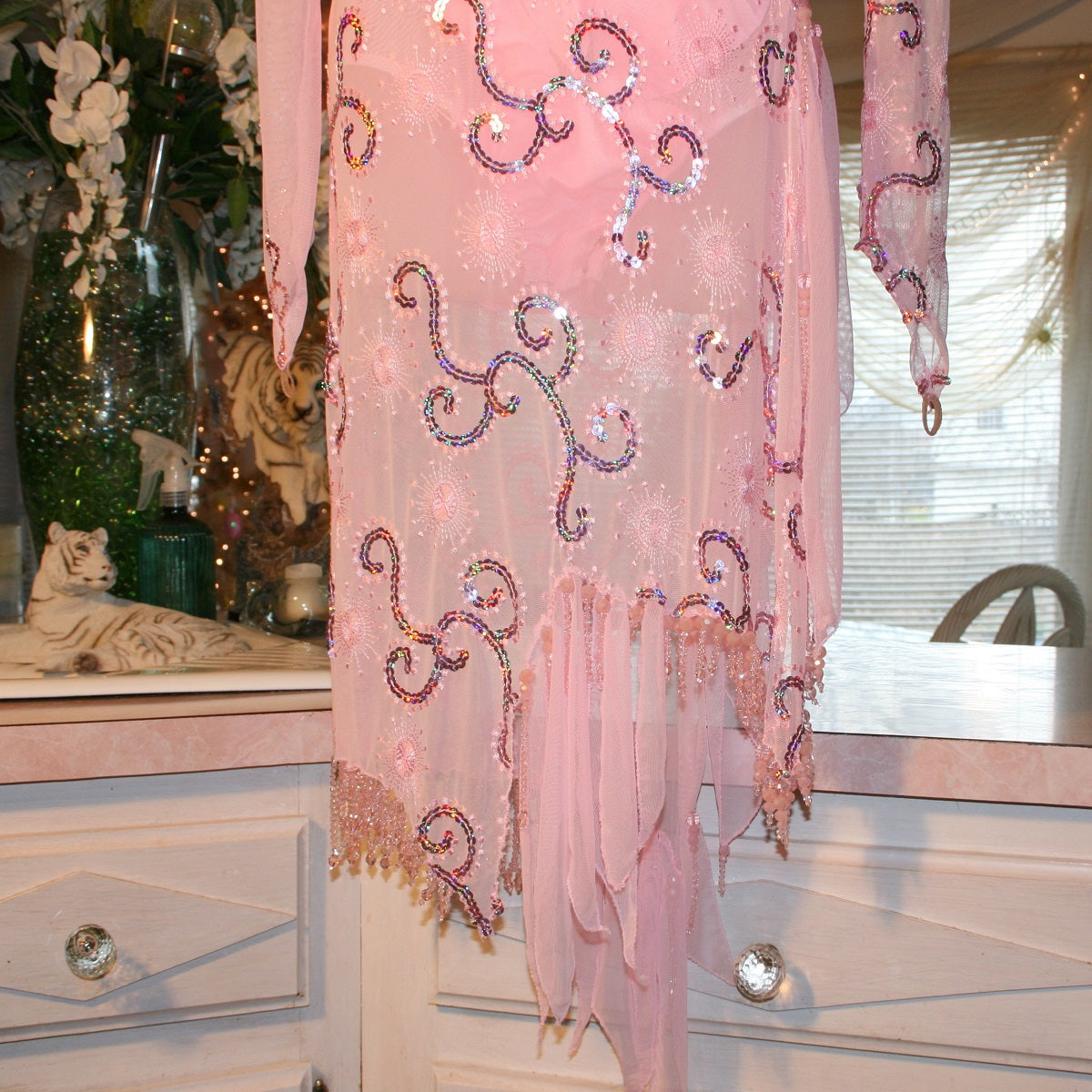 bead details of stunning pink Latin-Rhythm dress. Its delicate soft pink stretch mesh is adorned with a mesmerizing scroll design, highlighted by two shades of glimmering pink rhinestones in a beautiful scroll design on the back, upper bodice, and left sheer side. The extensive hand beading in the skirting adds the perfect touch of elegance
