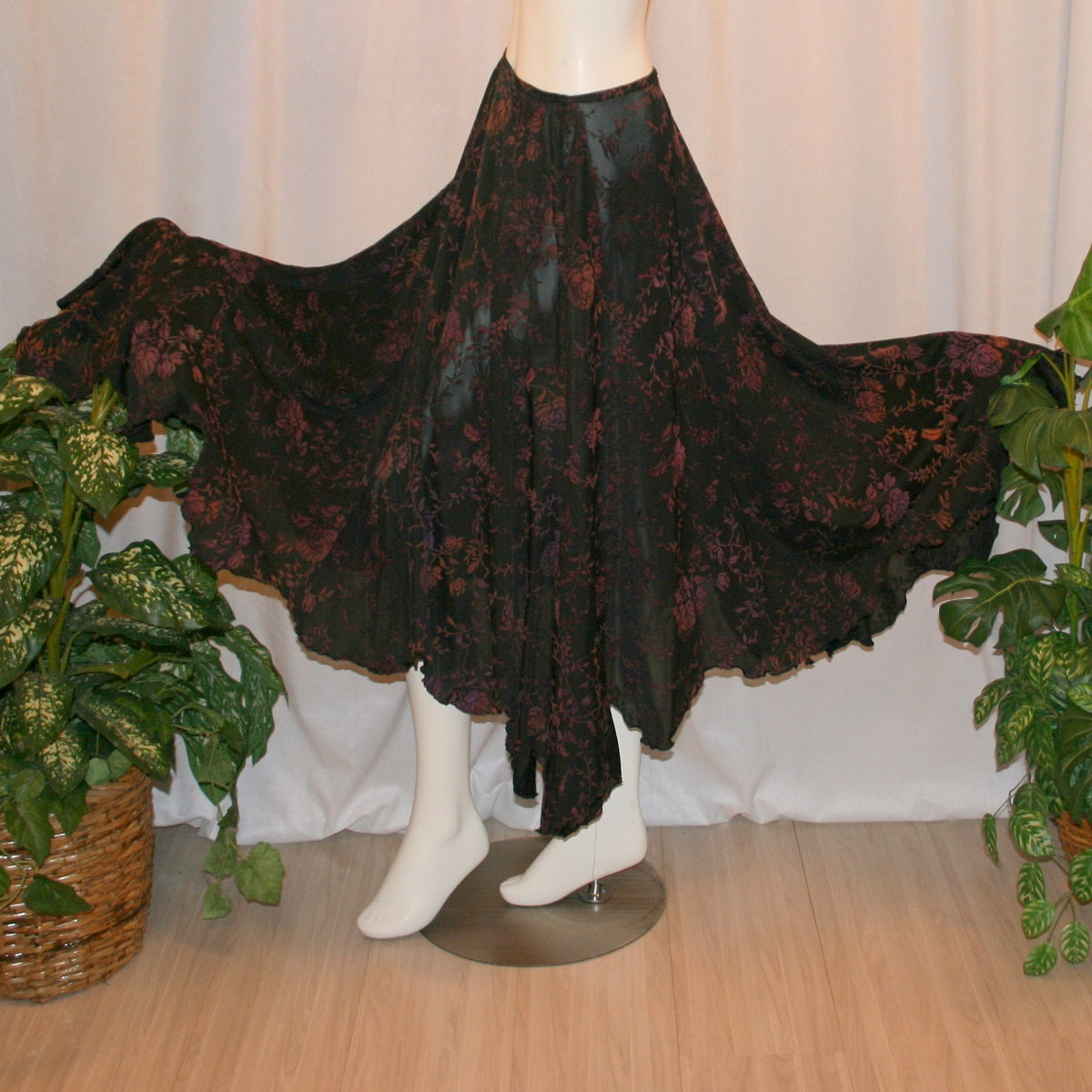side flared view of Black velveteen ballroom skirt with a gorgeous floral pattern, it creates a delightful swirl of autumn colors with its gored seaming and abundant fullness, and elasticized waist for ease of fit. Deep scalloped hemline adds a touch of charm, perfect for any ballroom event, studio dance parties, practice, or teaching!