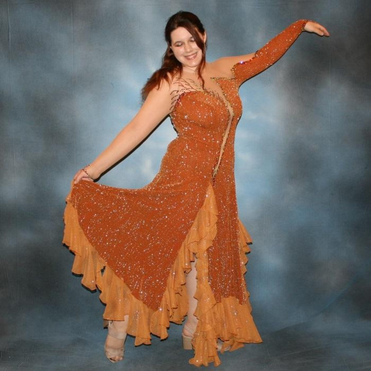 Crystal's Creations Bronze ballroom dress created in bronze glitter slinky with a swirl/ripple design on nude illusion base with oodles of amber glitter chiffon flounces, is embellished with volcano Swarovski rhinestone work.