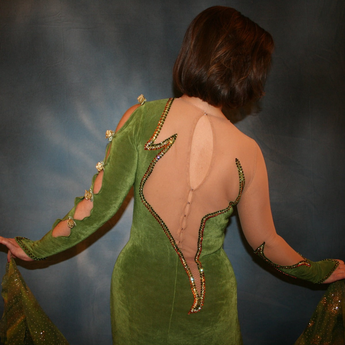 Crystal's Creations close up back view of Green ballroom dress created of luxurious olive green solid slinky on nude illusion base with glitter chiffon print flounces of olive greens & gold… embellished with olivine, jonquil & peach Swarovski rhinestones.