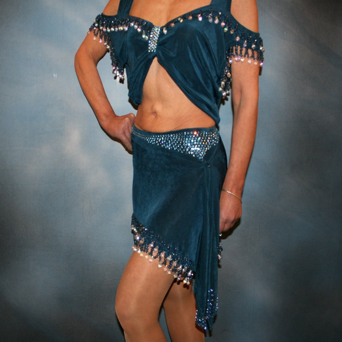 Crystal's Creations close up view of 2 piece blue Latin/rhythm dance dress was created of deep sea blue luxurious solid slinky with cascades of hand beaded fringe plus light sapphire Swarovski rhinestone work. The Latin dance skirt has built in tights.