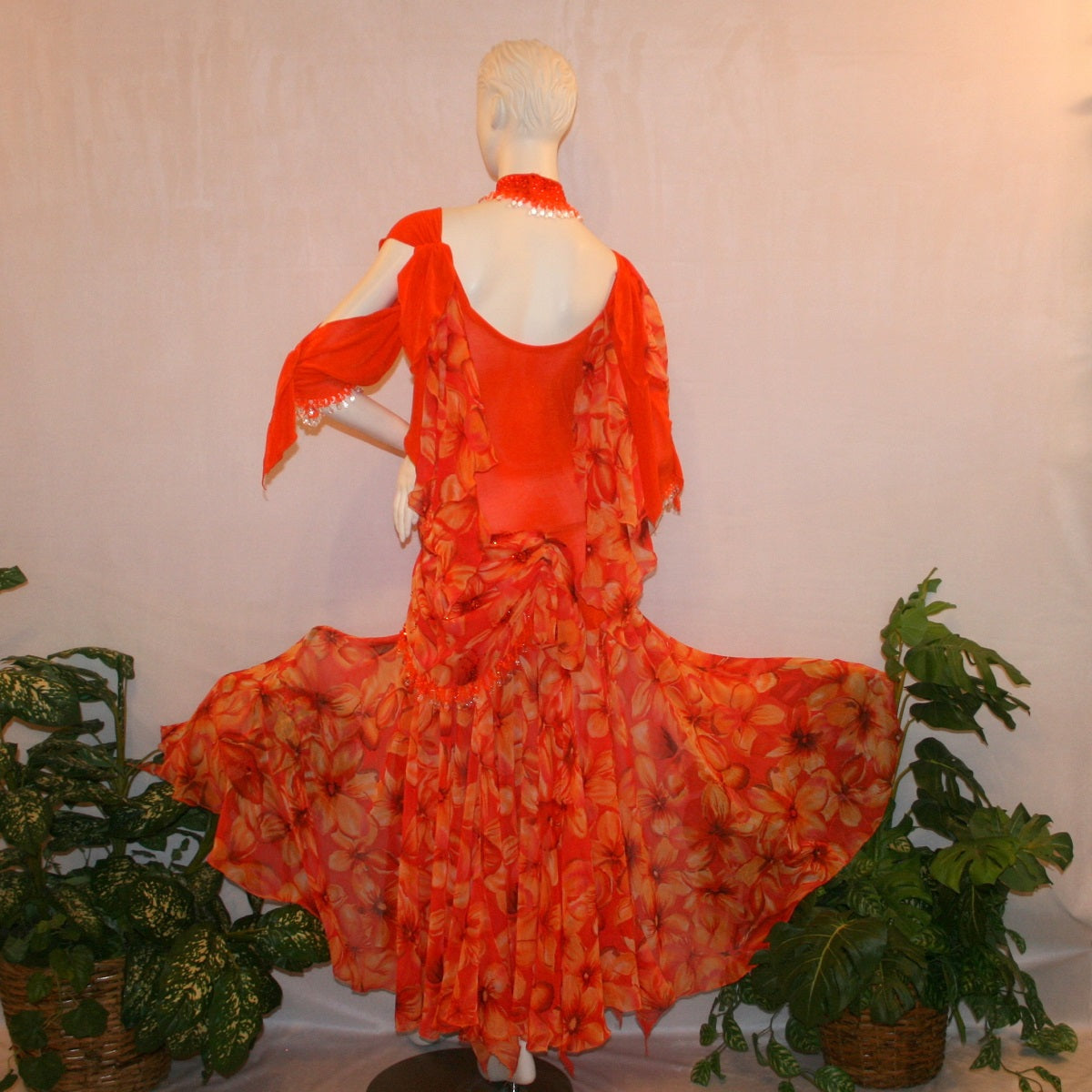 back view of Orange ballroom dress with 3/4 cold shoulder, billowy sleeves, created of luxurious orange solid slinky & yards of an orange tropical print textured chiffon.