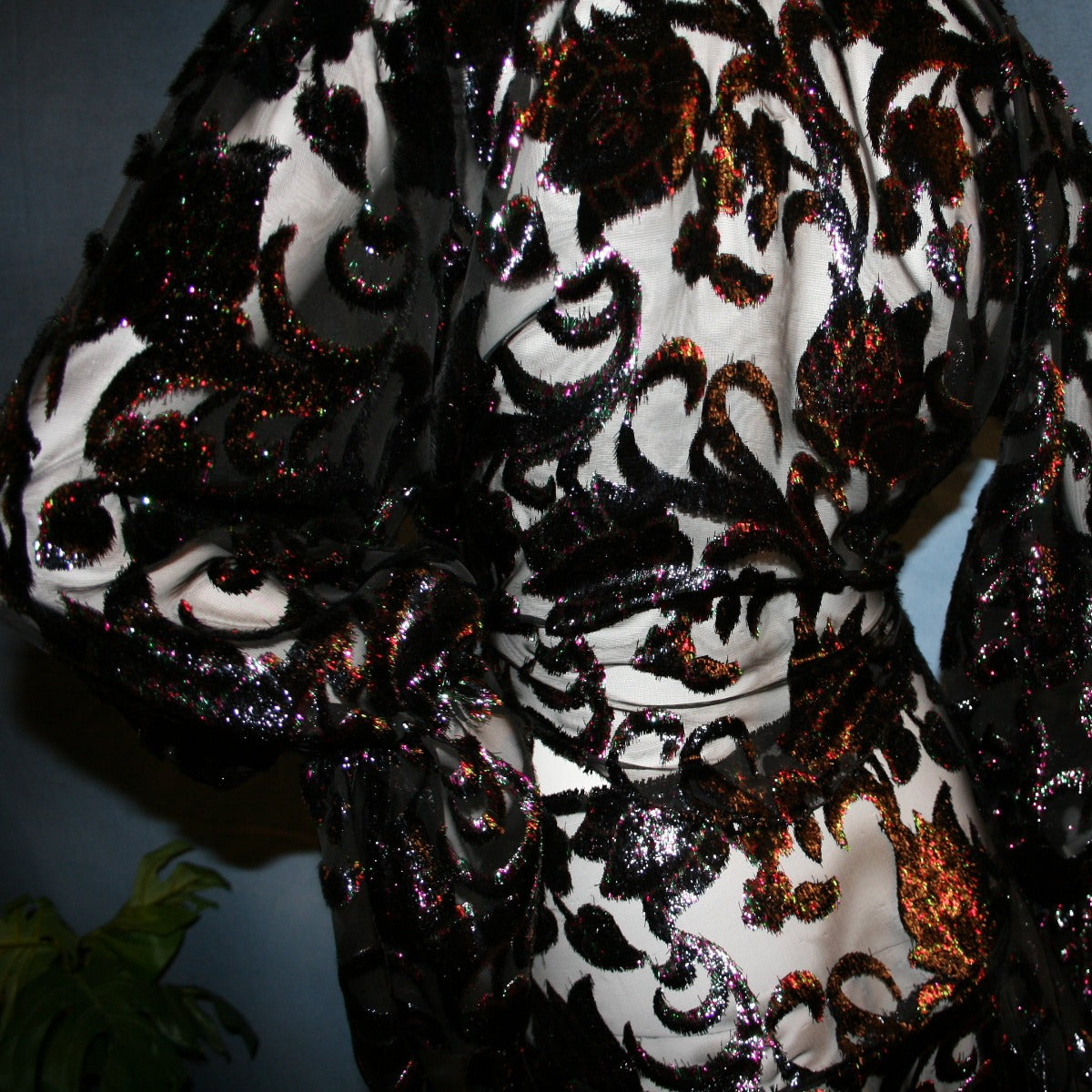 close up view of Black wrap style panel ballroom skirt was created of black, fuchsia, & emerald green metallic burnout velvet with matching long full sleeve midriff top. This gorgeous ballroom dance set is very sheer, so, wear dance pants & bra or tube top....or...a custom created midriff top to wear underneath the top would look fabulous...in either the fuchsia or emerald green to make it really POP on the ballroom dance floor!