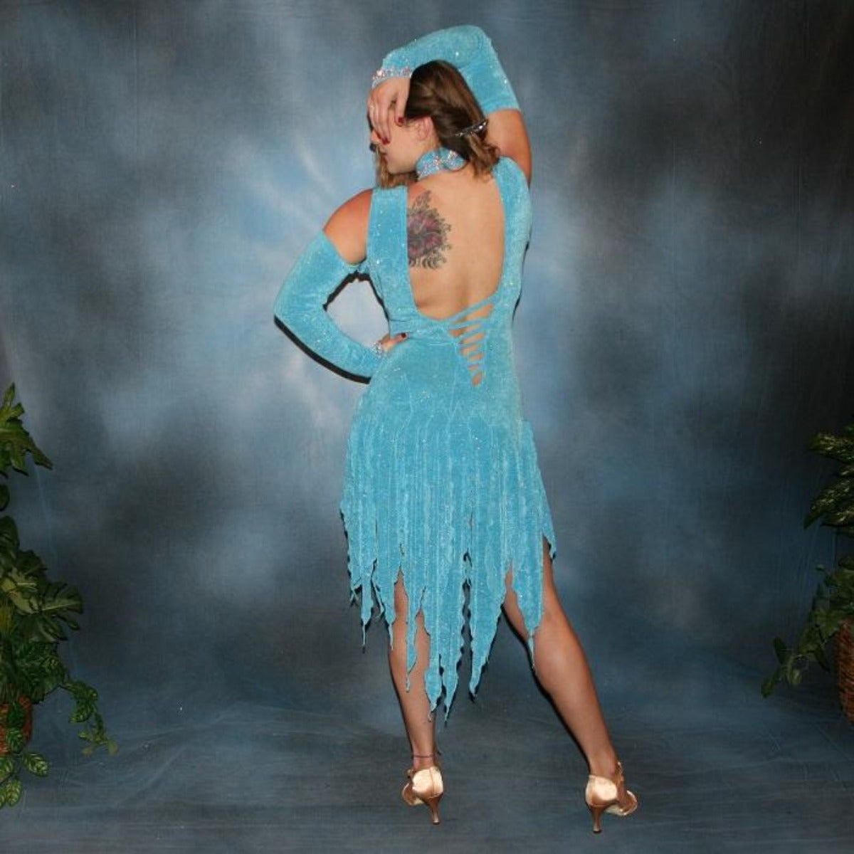 Crystal's Creations back view of Turquoise Latin/rhythm dress was created in turquoise slinky glitterknit, has interesting strap detailing on the back, embellished with CAB Swarovski rhinestone  work on the neck piece, & includes wrist bands or gauntlets with Swarovski rhinestone work.