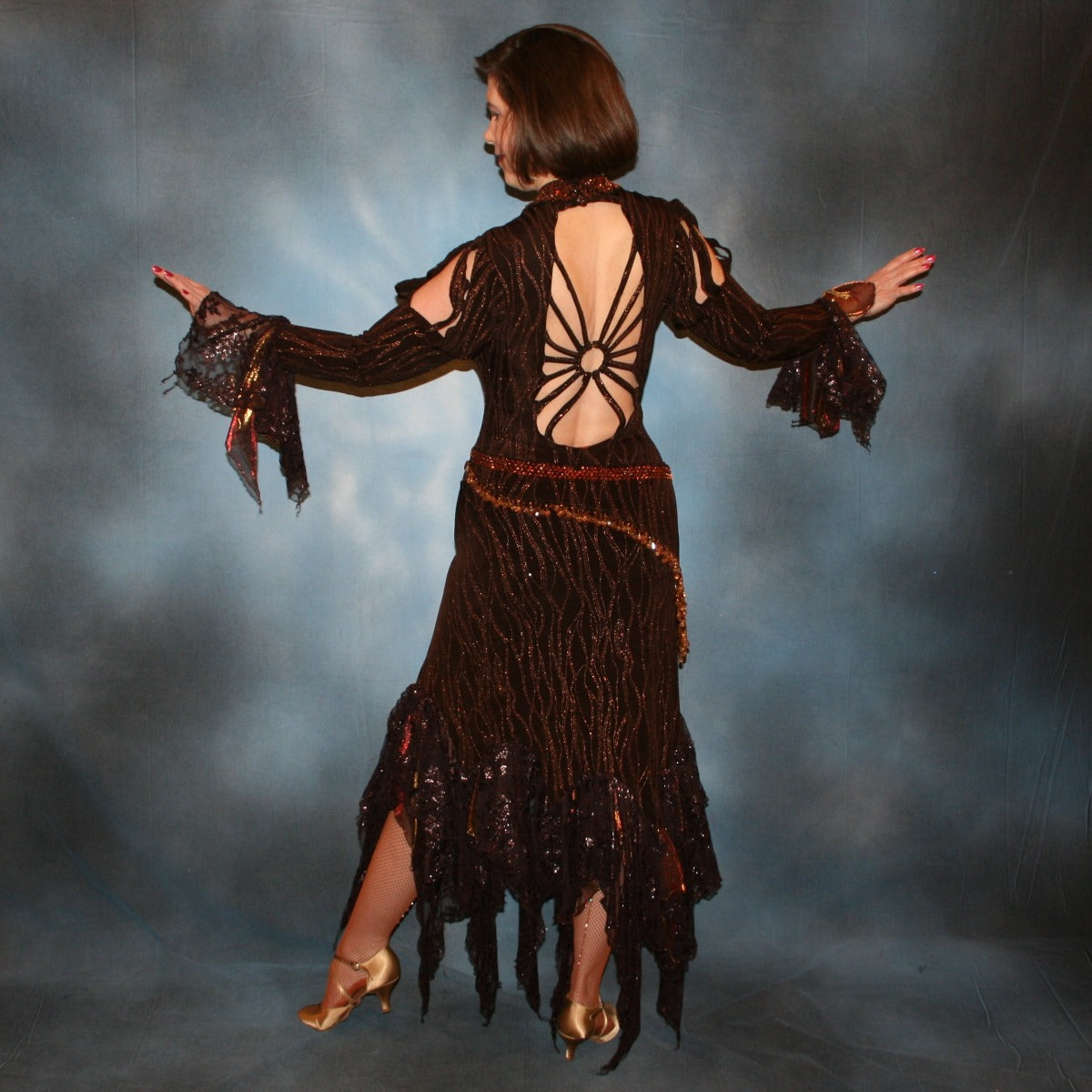 back view of Brown tango dress, bolero dress or rumba dress created in chocolate brown & bronze glitter slinky with chocolate brown metallic lace & metallic tricot flounces is embellished with crystal copper Swarovski rhinestones at neckpiece & hipsash, which also has extensive hand beading.