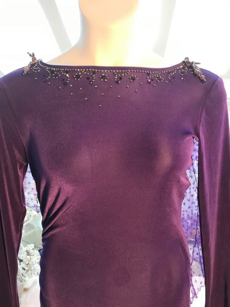 Close up of Crystal's Creations Purple Latin/rhythm/tango dress created of deep grape purple solid slinky with a touch of Swarovski rhinestone work done in metallic light gold & deep velvet purple, along with some hand beading & some gorgeous glittery floats.