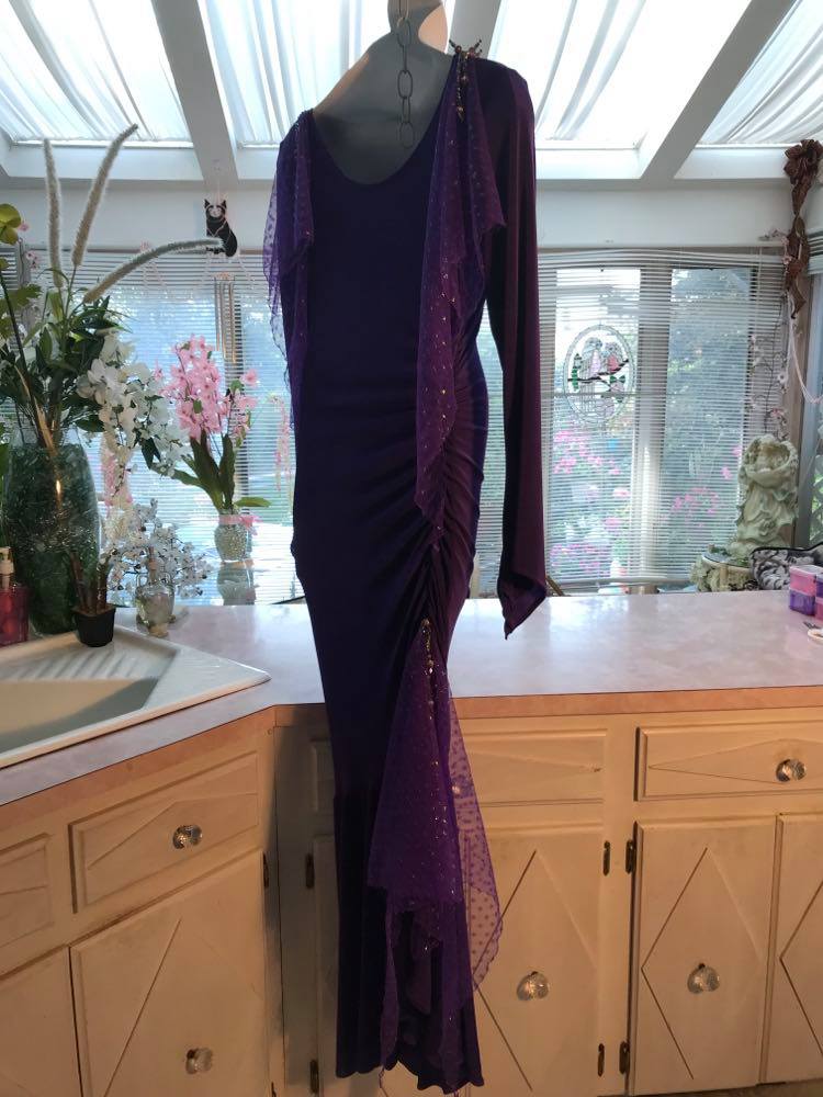 Side view of Crystal's Creations Purple Latin/rhythm/tango dress created of deep grape purple solid slinky with a touch of Swarovski rhinestone work done in metallic light gold & deep velvet purple, along with some hand beading & some gorgeous glittery floats.