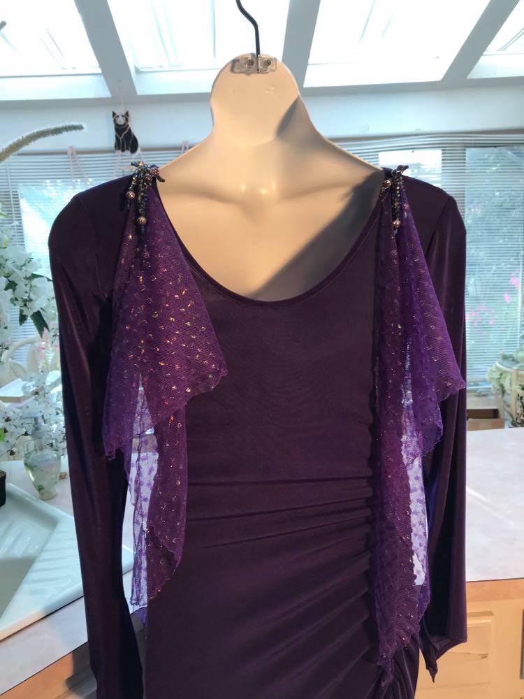 Close up back view of Crystal's Creations Purple Latin/rhythm/tango dress created of deep grape purple solid slinky with a touch of Swarovski rhinestone work done in metallic light gold & deep velvet purple, along with some hand beading & some gorgeous glittery floats.