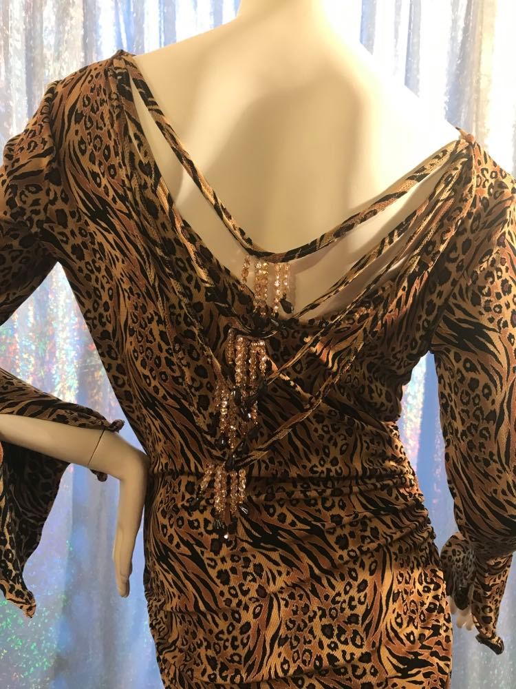 close up back view of Latin/rhythm/tango dress created in serengeti print slinky with ruching, long flared sleeves, with Swarovski bead details on back.