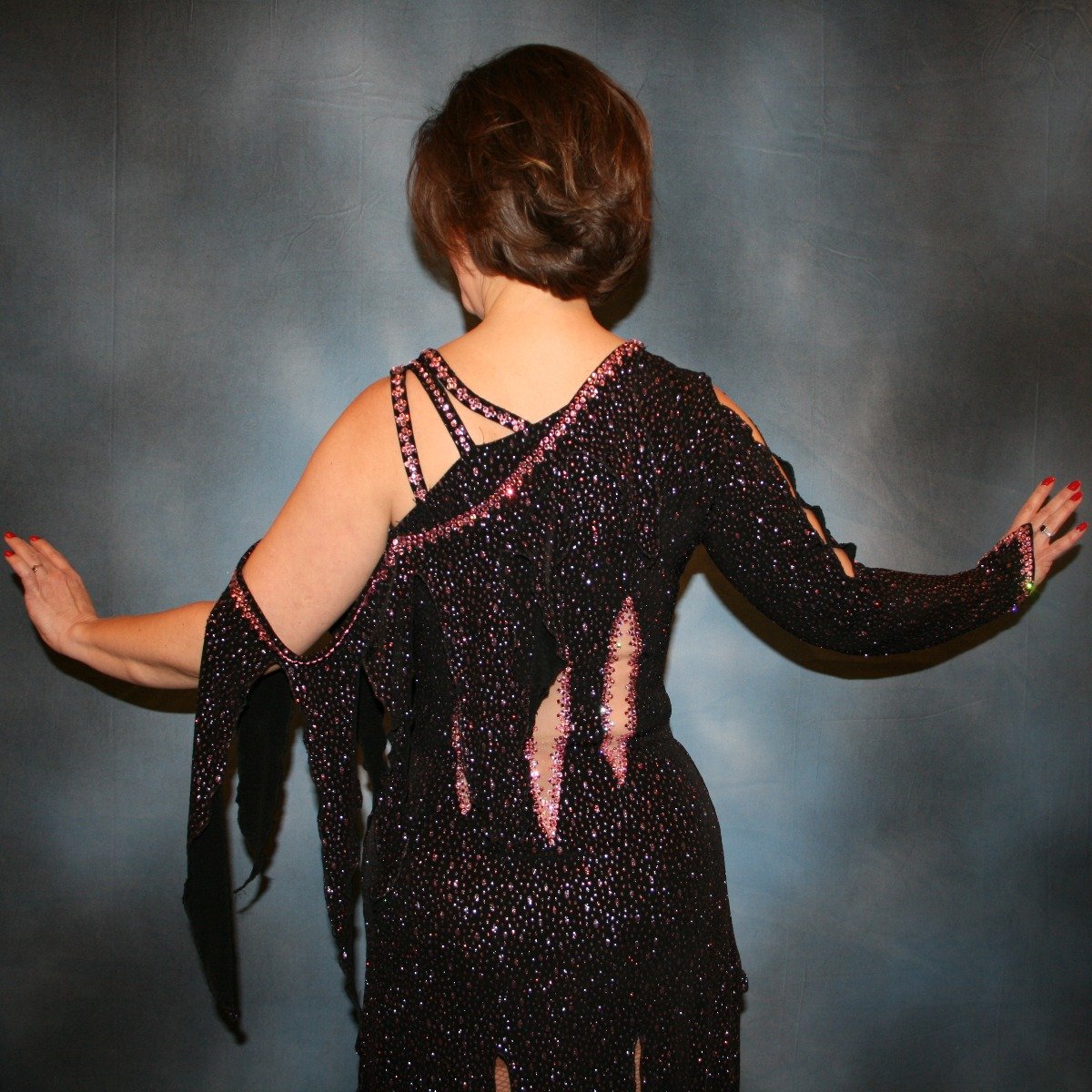 Crystal's Creations back close up view of Black Latin/rhythm dress created in black glitter slinky with light pink glitter accents that look like champagne bubbles is embellished with light pink Swarovski rhinestone work