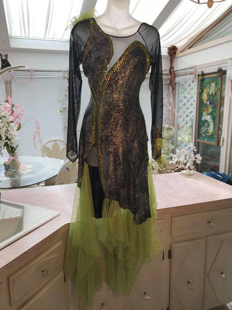 Crystal's Creations silver Latin/rhythm dress created of silver swirls glitter slinky fabric artisically cut & laid over sheer black stretch mesh features lime green scarf shape flounces & Olivine Swarovski rhinestone work.  size 5/6-9/10