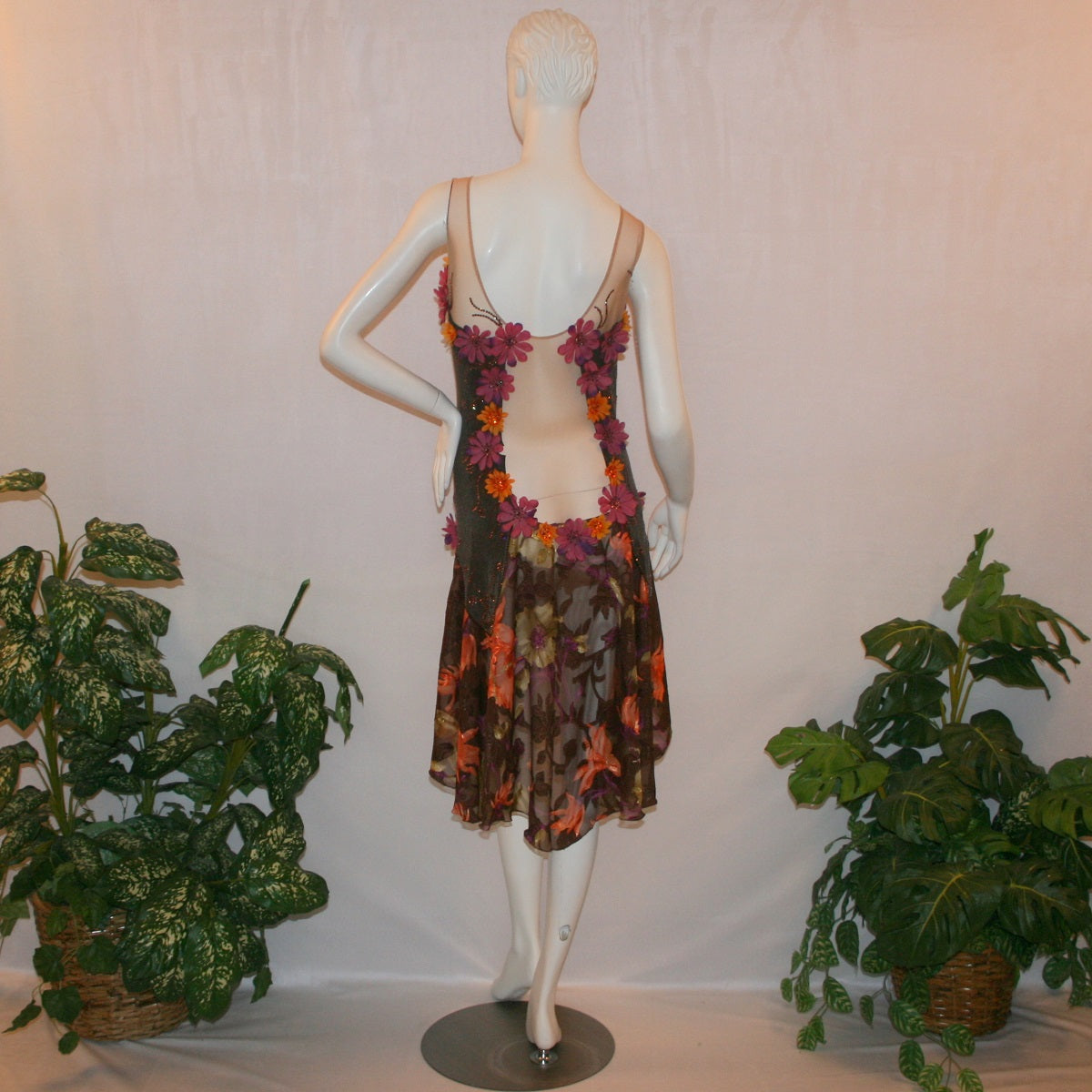 back view of Latin-rhythm dress of Brown converta ballroom dress created in deep chocolate brown slinky on a nude illusion base with panels of a gorgeous flowered chiffon with a sheen in browns, oranges, yellows, greens, burgundies & purples, with silk flower embellishments & Swarovski detailed rhinestone work.