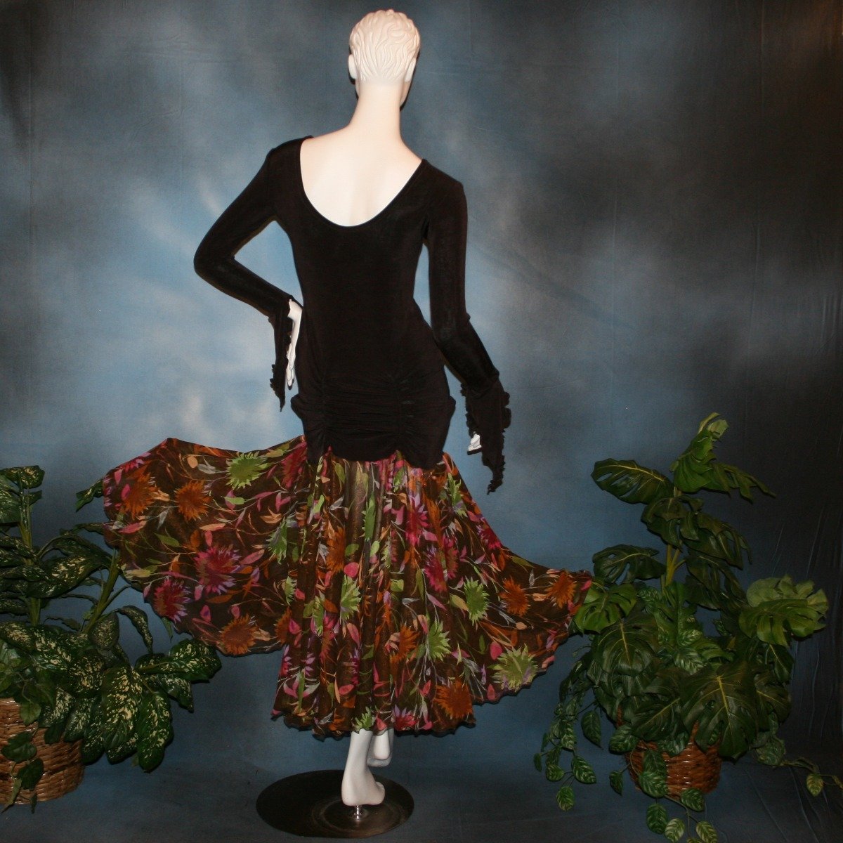 Crystal's Creations back view of Deep chocolate brown social ballroom dress created of luxurious deep chocolate brown solid slinky base featuring ruching through the hip area, & interesting long flared sleeves, with yards of fall colored flowers chiffon petal panels