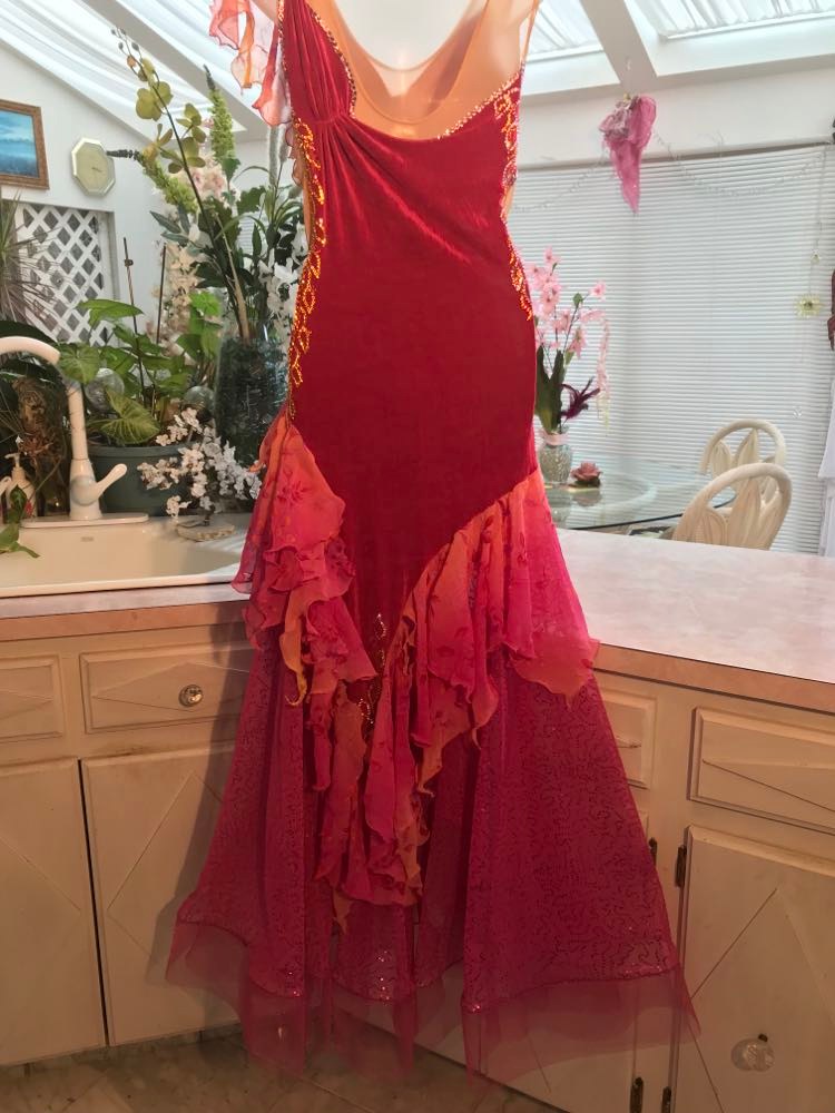 back view of Gorgeous rose colored converta ballroom dance dress was created on a nude illusion base of rose colored slinky with flounces of a gorgeous oriental flower print crinkle chiffon of pinks, yellows & oranges. Detailed Swarovski rhinestone work which ties in so beautifully with with the print chiffon, is done in pinks, yellows & orange.