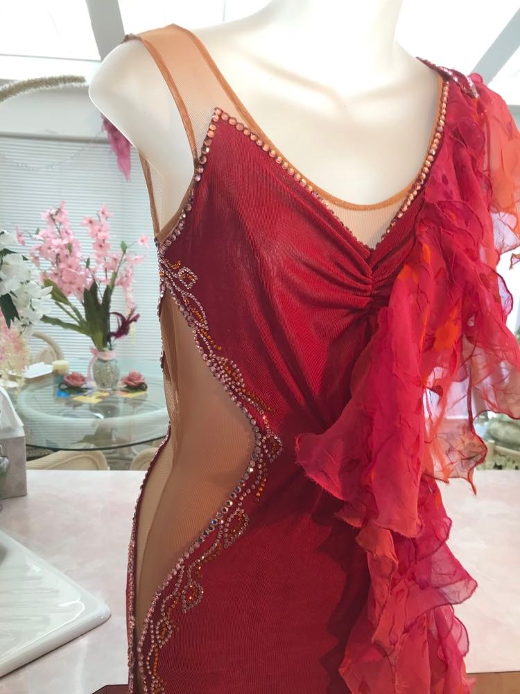 close up view of Gorgeous rose colored converta ballroom dance dress was created on a nude illusion base of rose colored slinky with flounces of a gorgeous oriental flower print crinkle chiffon of pinks, yellows & oranges. Detailed Swarovski rhinestone work which ties in so beautifully with with the print chiffon, is done in pinks, yellows & orange.