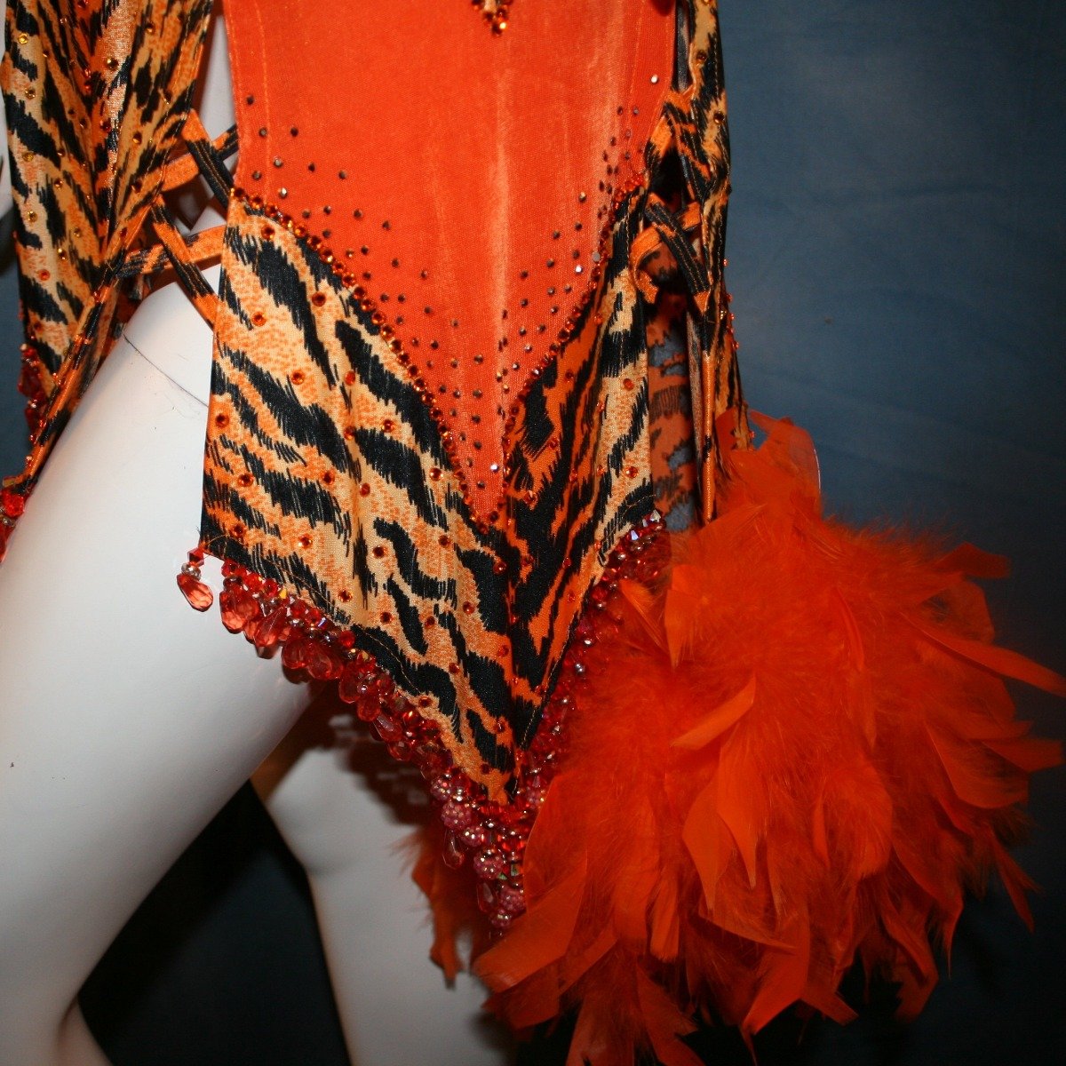 Crystal's Creations close up bottom view of orange & black tiger print Latin/rhythm dress with orange chandelle feathers & hand beading