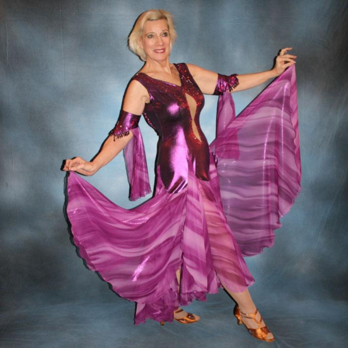 Crystal's Creations right side view of Purple/plum ballroom dress created of rich & luxurious plum metallic slinky ballroom dance dress with yards & yards of print chiffon… embellished with fuchsia Swarovski rhinestones… along with hand beading of bicone & teardrop Swarovski beads