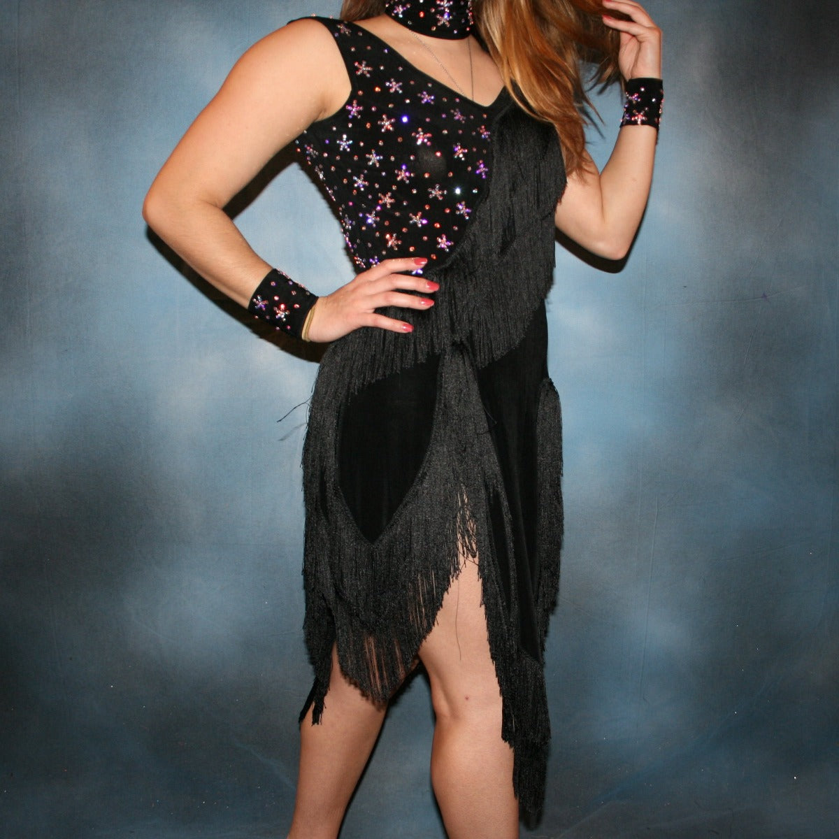 Crystal's Creations close up view of Black Latin/rhythm dress with fringe created in luxurious black solid slinky with silky black chainette fringe, wristbands, matching choker, embellished with CAB Swarovski rhinestones, about 7 gross.