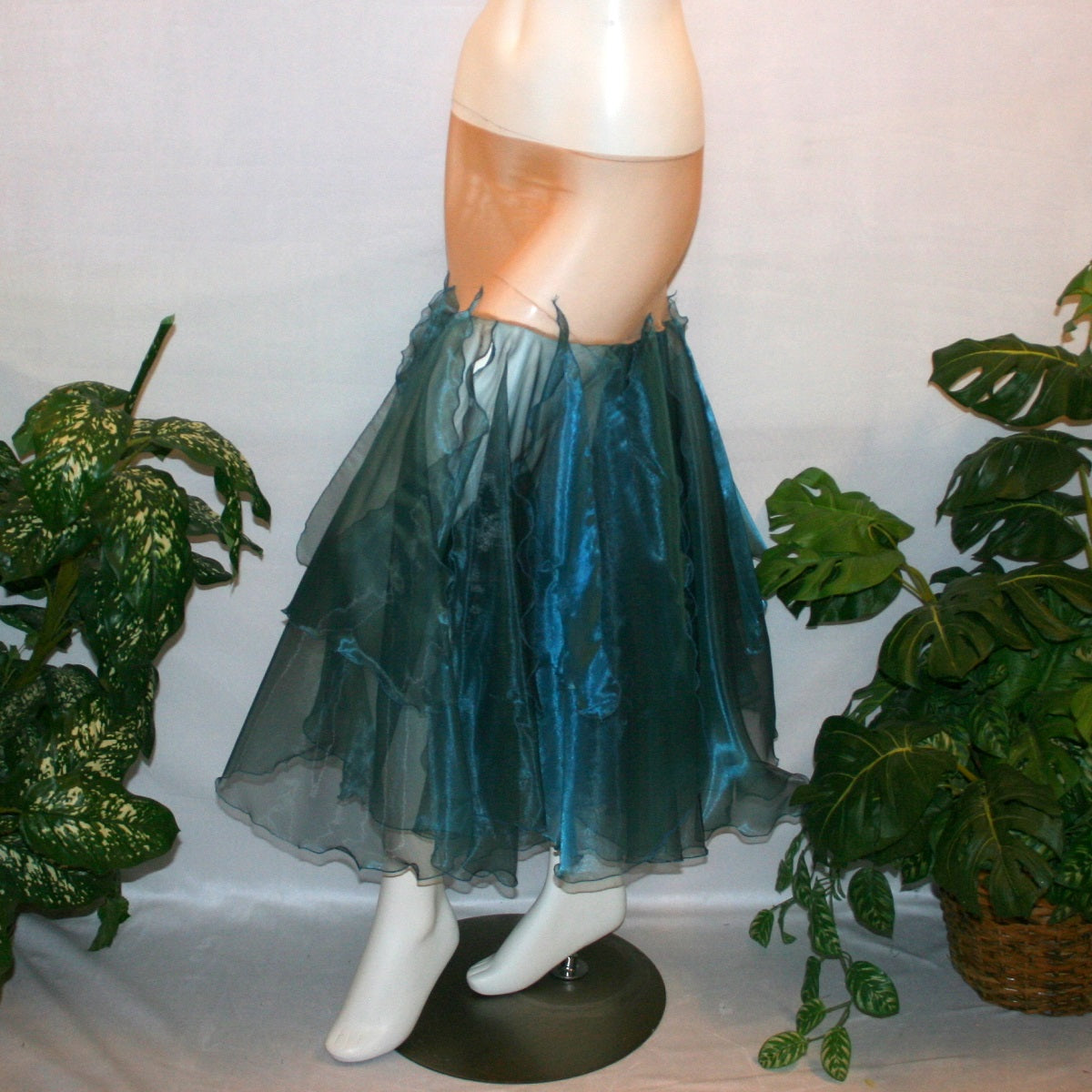 side view of Blue ballroom skirt created with yards of a deep sea blue organza, layers of large petal shaped panels.