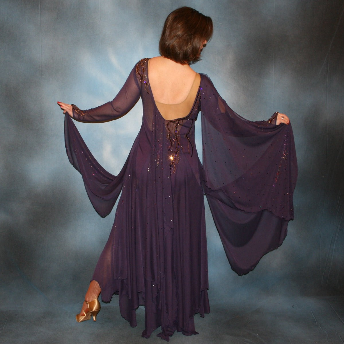Crystal's Creations back view of Purple ballroom dress created in gorgeous deep plum iridescent sheer mesh with draping floats, embellished with gold aurum & purple velvet Swarovski rhinestone work