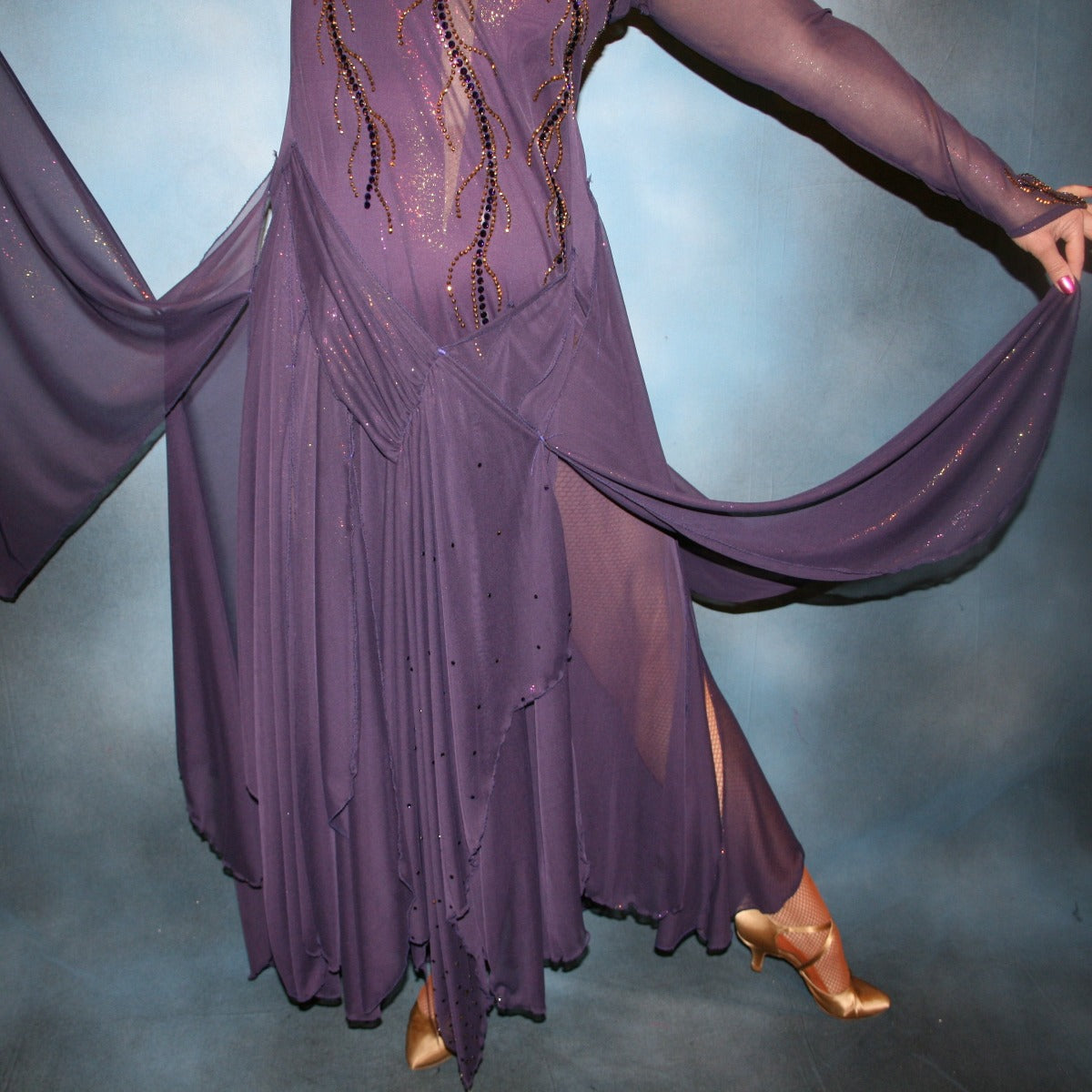 Crystal's Creations close up of bottom of Purple ballroom dress created in gorgeous deep plum iridescent sheer mesh with draping floats, embellished with gold aurum & purple velvet Swarovski rhinestone work