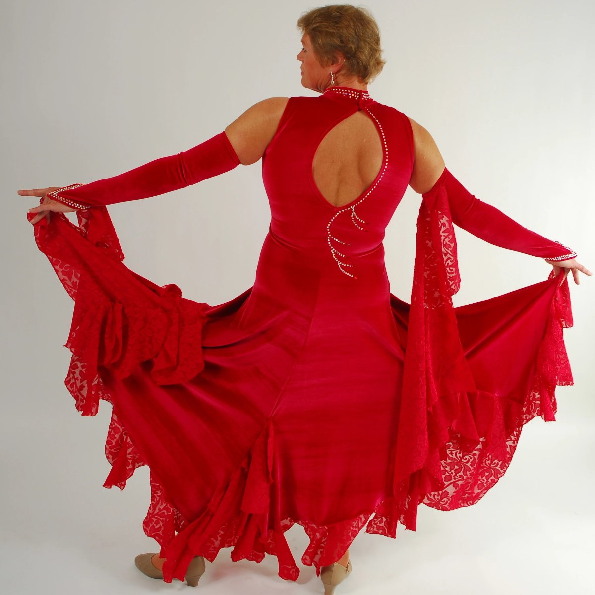 back view of Red ballroom dress was created in luxurious red stretch velvet with clip-n-cut chiffon insets & flounces & inset down bodice with matching gauntlets...embellished with CAB Swarovski rhinestones & has keyhole back.