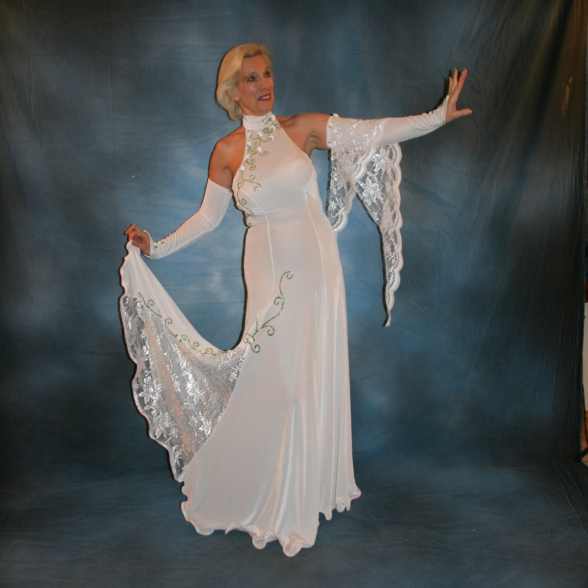 Crystal's Creations White ballroom dance dress was created in luxurious white stretch velvet with sequined lace insets & arm float, embellished with green peridot Swarovski detailed rhinestone work & miniature silk roses
