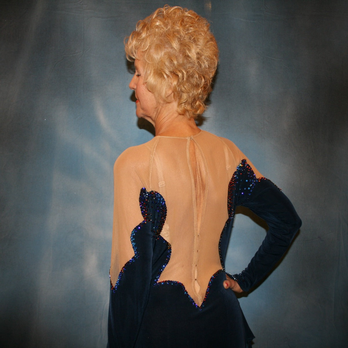 Crystal's Creations close back view of Navy blue Latin/rhythm dress was created in luxurious navy blue solid slinky, featuring flounce/tails of specialty fabric in shades of navy & blues, is embellished with meridian blue Swarovski rhinestones, with built in nude illusion body contouring bodysuit base.