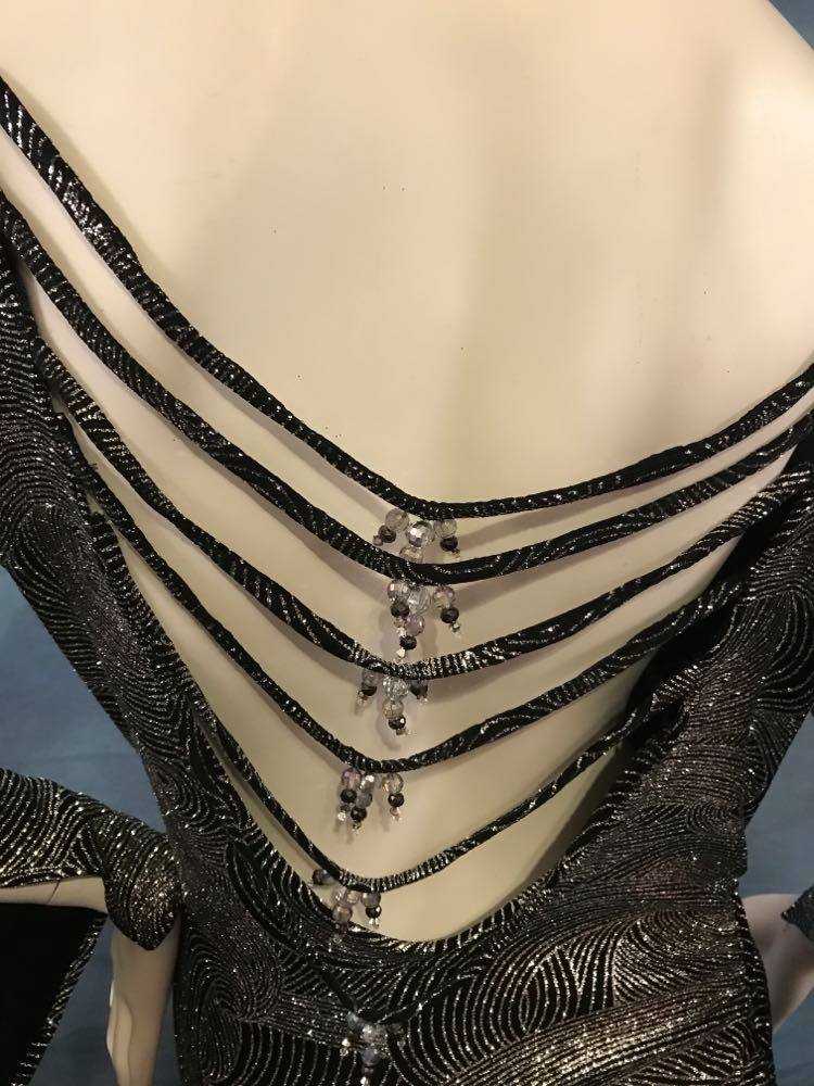 Crystal's Creations back details of Silver Latin/rhythm/tango dress created of silver swirls glitter slinky with sleek & elegant lines, long flared sleeves & low back with strap details size 5/6-11/12, very stretchy