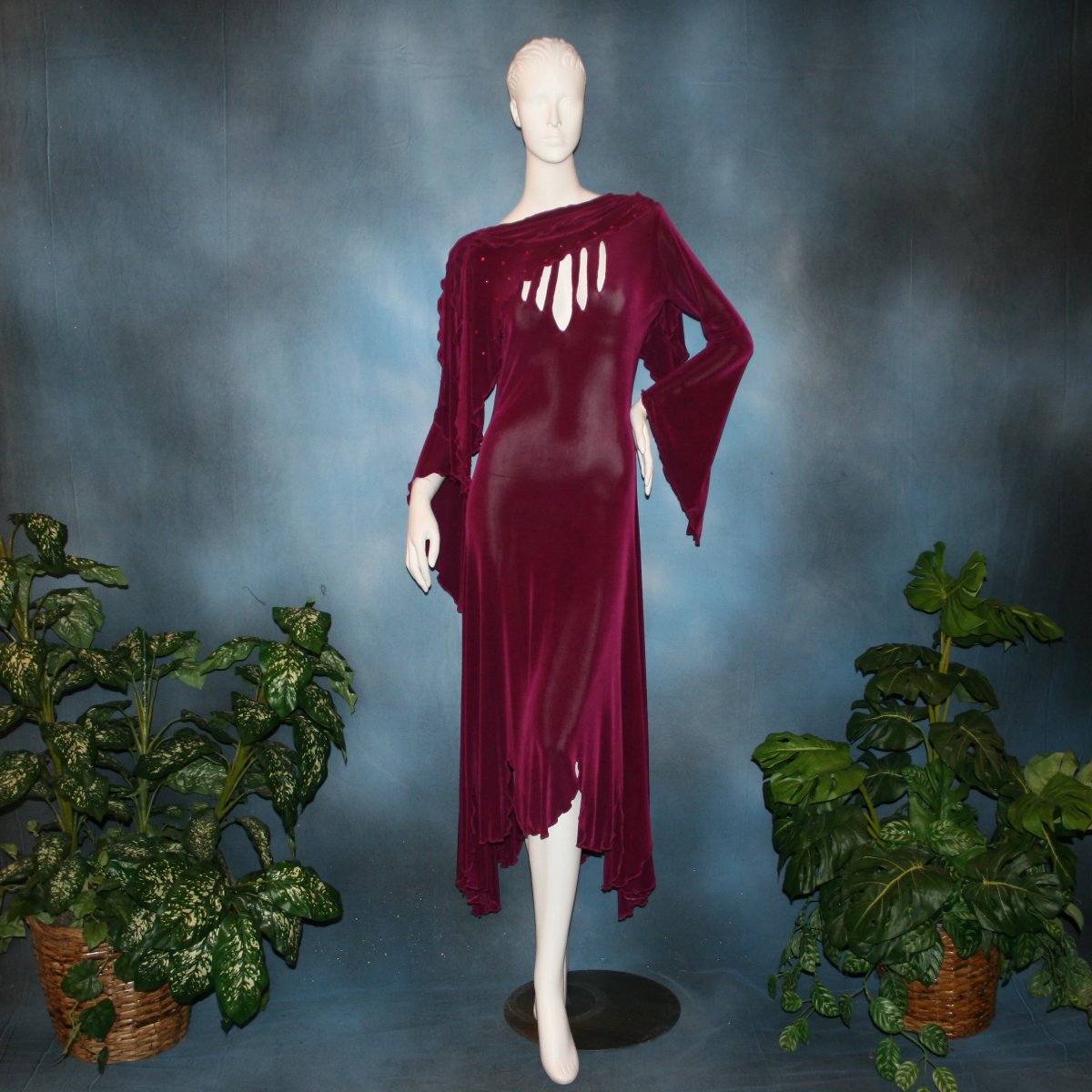 Magenta social ballroom dress created in luxurious solid slinky fabric with cutouts at bustline & attached double draping on shoulders, embellished with magenta Swarovski rhinestones, features a scalloped skirt edge. Very full around bottom & can be a beginner ballroom dancer smooth ballroom show or competition dress.