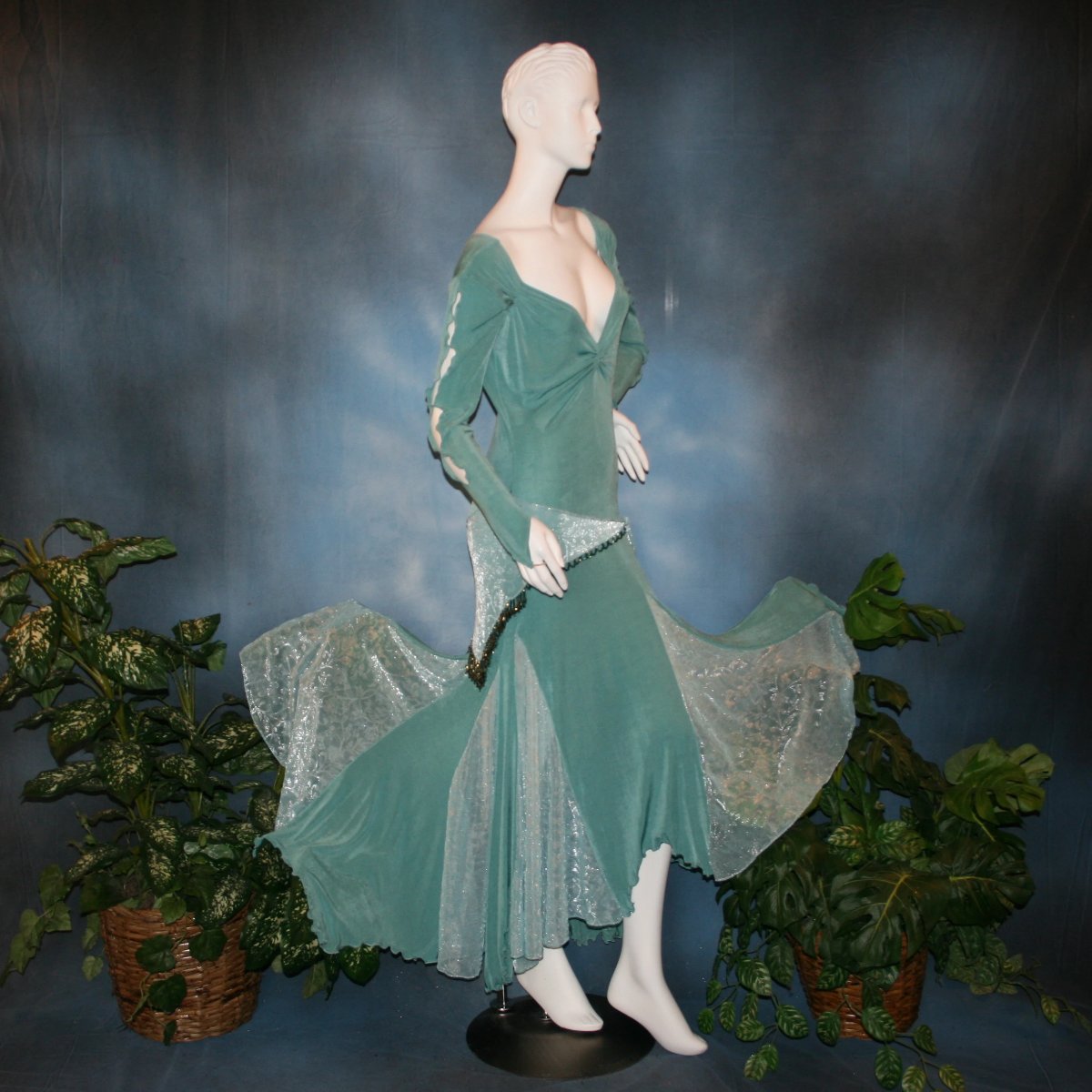 side view of Aqua social ballroom dress created in luxurious aqua solid slinky fabric with aqua iridescent sheer insets, embellished with hand beading of Swarovski beads on hip sash. Very full around bottom...can be a beginner ballroom dancer smooth ballroom dress.