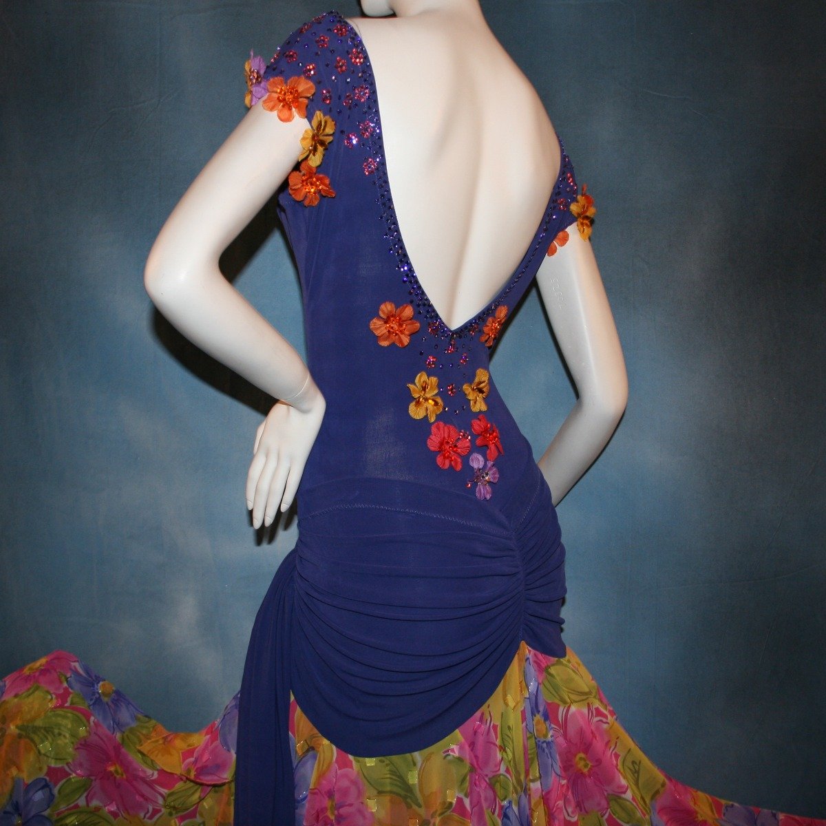 Crystal's Creations back view of Converta ballroom dress featuring a Latin/rhythm dress created in luxurious deep perwinkle solid slinky with lots of flounces in accents of a floral chiffon in yellow with pinks & purples