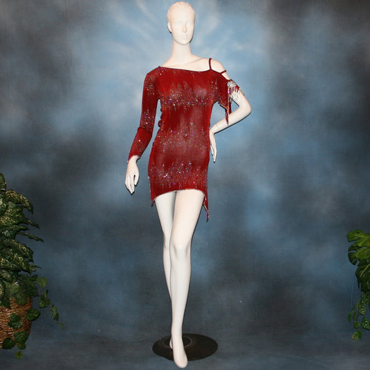 Deep scarlette red Latin rhythm dress created in glitter slinky with an awesome electrifying glitter pattern features lattice detailing in the sides, one long sleeve & interesting detailing on the opposite shoulder with Swarovski hand beading & Crystal Ab rhinestone work edging the skirting, split cape sleeve & long sleeve.