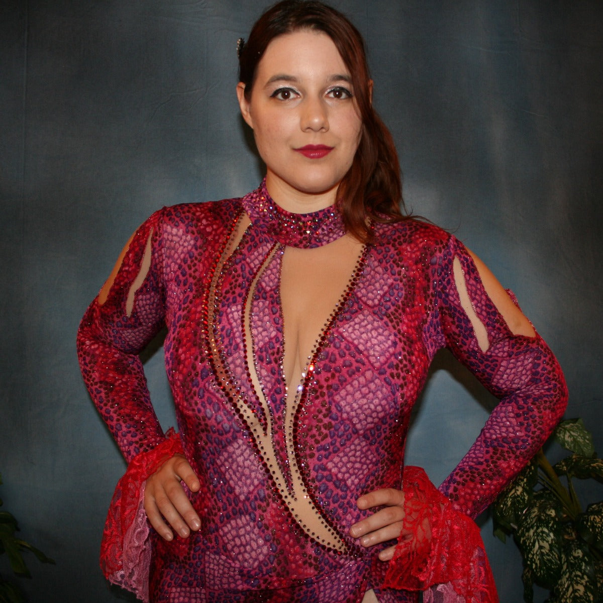 Crystal's Creations close up view of Red & purple Latin/rhythm dress created in gorgeous printed slinky glitterknit in reptilia print of reds, purples & orchids with nude illusion cutouts…oodles of lace flounces…embellished with siam & siam Ab Swarovski stonework.