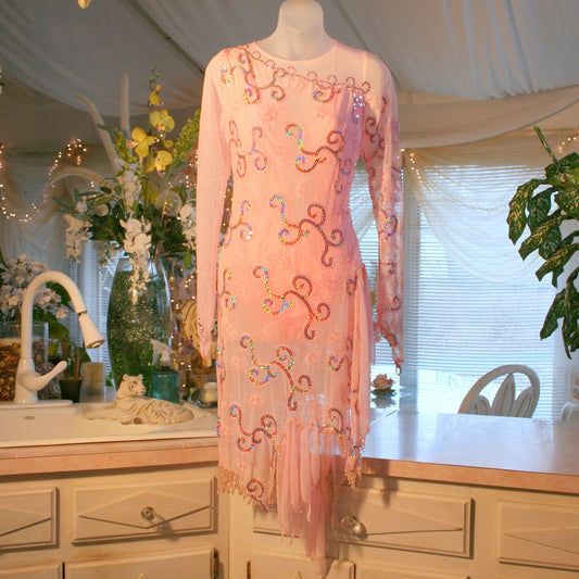 stunning pink Latin-Rhythm dress. Its delicate soft pink stretch mesh is adorned with a mesmerizing scroll design, highlighted by two shades of glimmering pink rhinestones in a beautiful scroll design on the back, upper bodice, and left sheer side. The extensive hand beading in the skirting adds the perfect touch of elegance