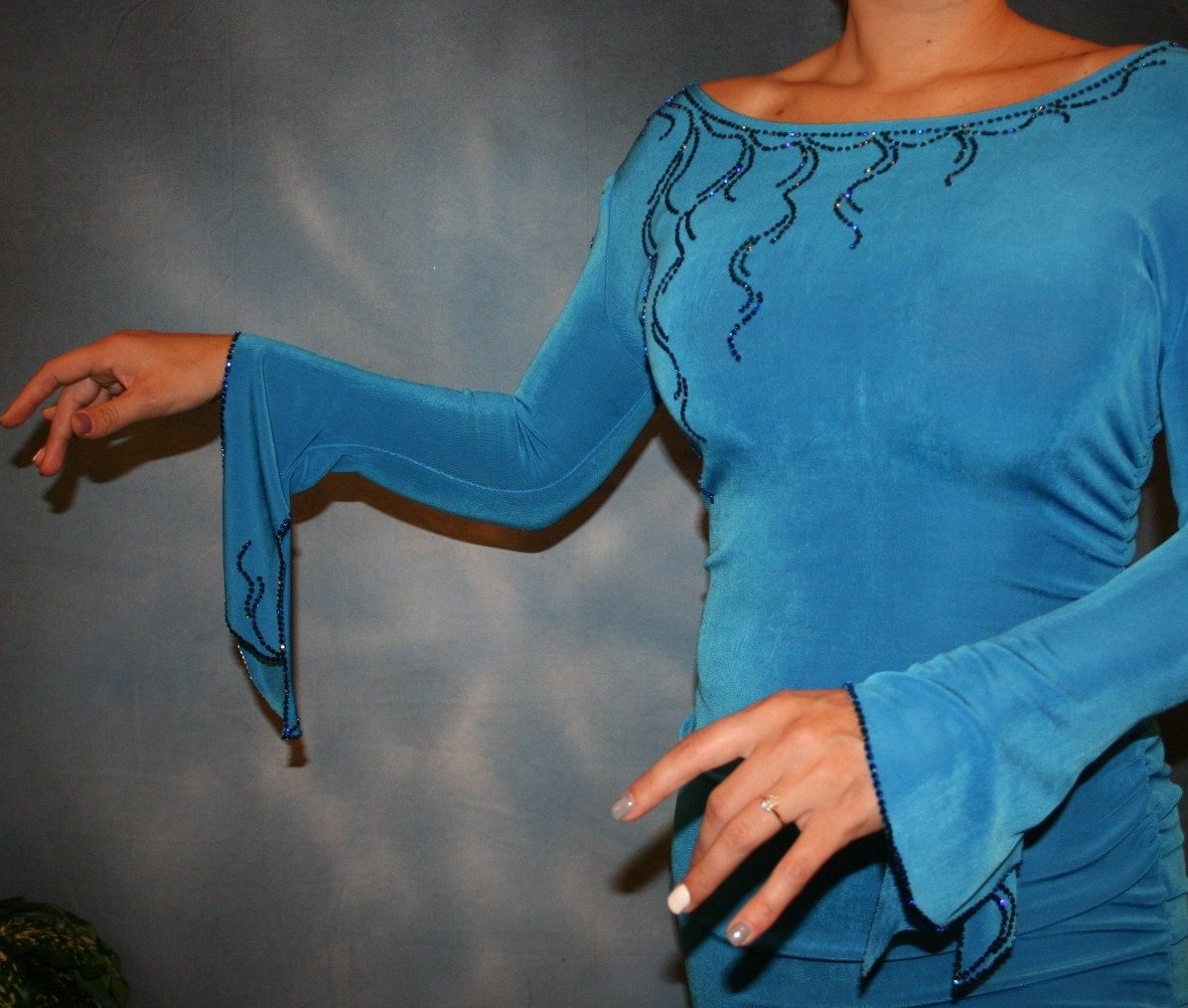 top view of Crystal's Creations blue Latin/rhythm dress created of luxurious blue slinky, embellished with Swarovski detailed rhinestone work