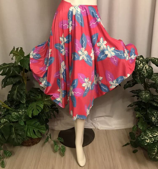 Flared front view of dance skirt Made of a vibrant deep pink and blue tropical print lycra, this mid-calf skirt is designed with a fullness that flows beautifully on the dance floor. Perfect for tropical theme parties,