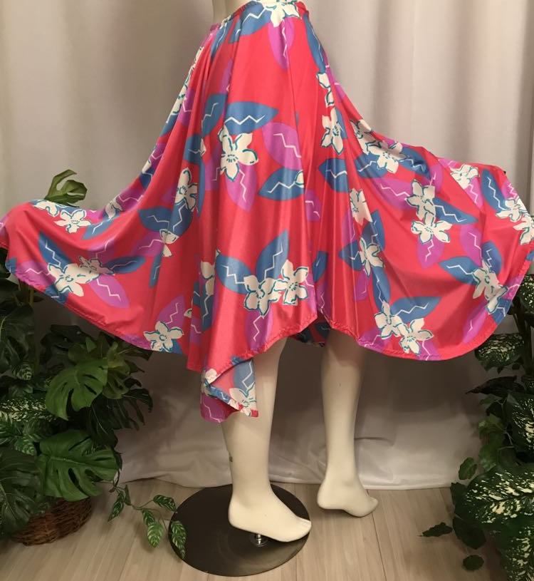 Side flared view of dance skirt Made of a vibrant deep pink and blue tropical print lycra, this mid-calf skirt is designed with a fullness that flows beautifully on the dance floor. Perfect for tropical theme parties,