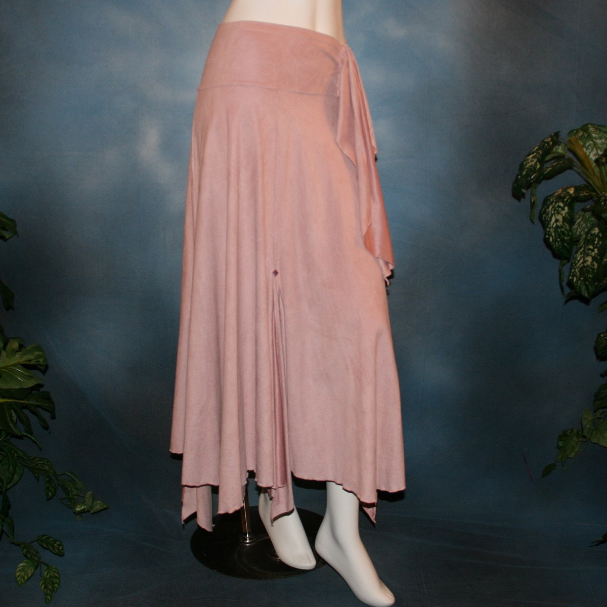Lovely light rose dance skirt created of slightly stretchable suede cloth featuring a wide waist sash that flares out to several panels, with slits that have smaller floating panels with a rose colored acrylic gem at each.