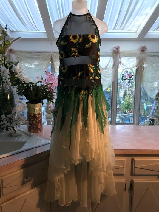 All around ballroom dress of sunflower print features yards of gorgeous soft yellow champagne sequin chiffon hand cut in large petal shapes for the skirting that is short in front & cascades longer in the back. Overlays of emerald flocked green chiffon skillfully hand crafted creating thin leaf shapes. Flows so beautifully for your foxtrots & waltzes! Lots of sparkle comes from the detailed rhinestone work