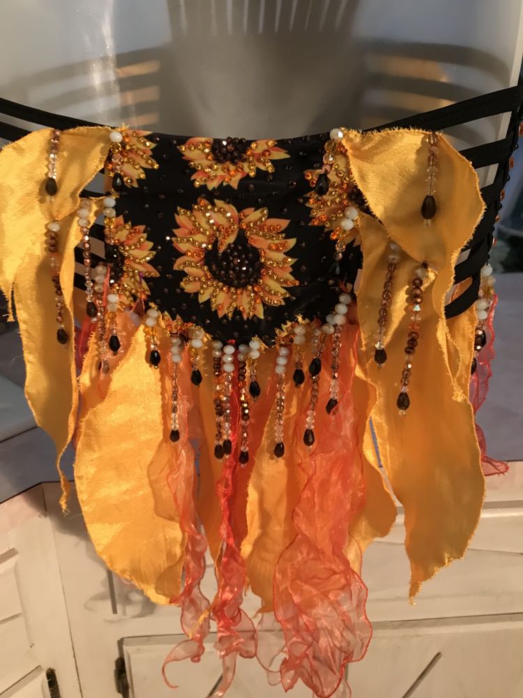 Back bottom view of sunflower print Latin-rhythm dress created from a very strappy detailed bathing suit which I added hand crafted petal shape flounces in sunflower yellow satin & orange variegated organza, with extensive Swarovski hand beading in orange, pearlescent, gold & black faceted beads in round & tear drop shapes along with Swarovski rhinestone work throughout in yellow, orange & bronze.