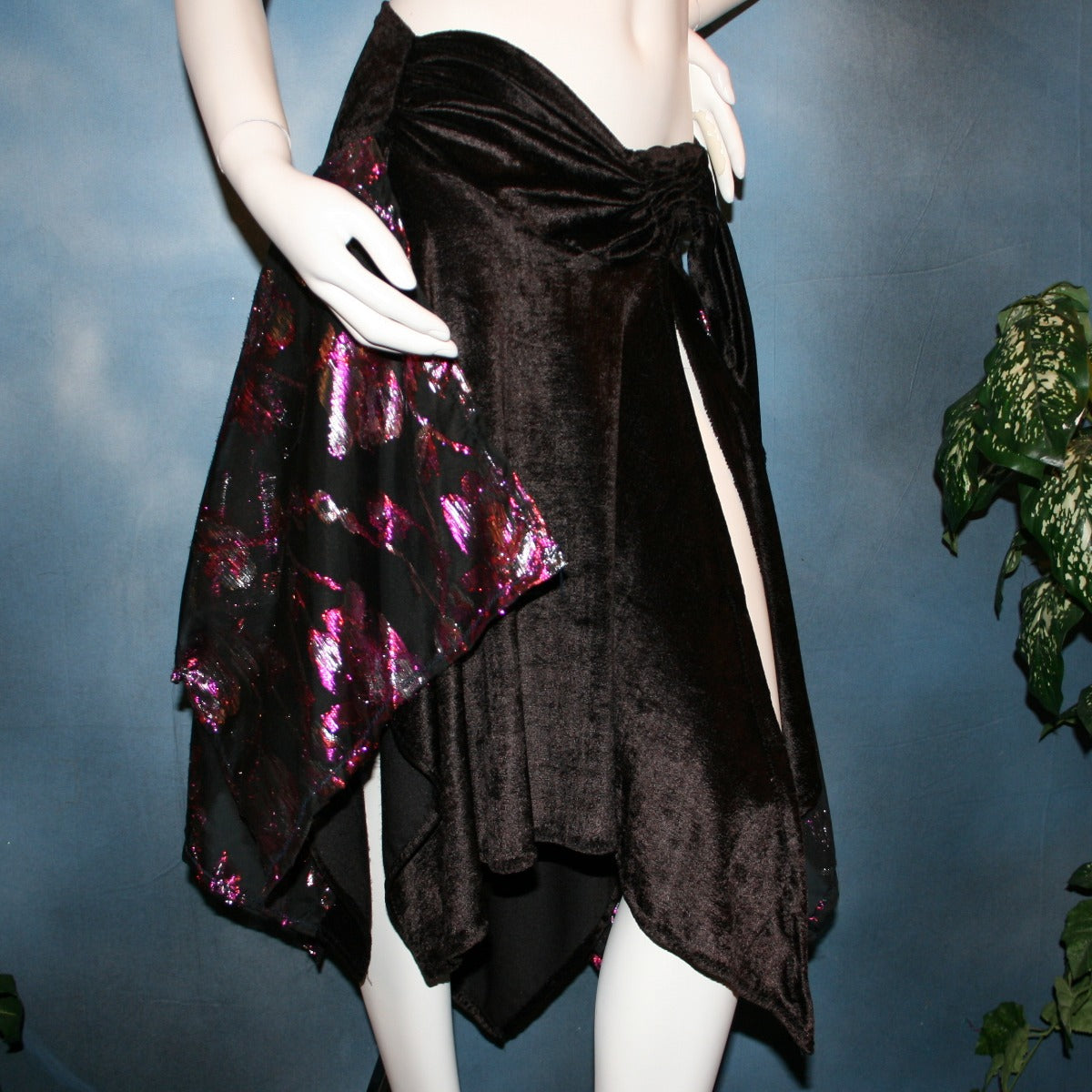 left side view of Black Latin/rhythm skirt, wrap style,with scarf cut panels was created with yards of a black & fuchsia metallic cut & clip chiffon on a panne' velvet base with ruching & sash.