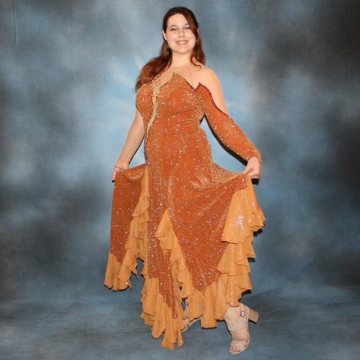 Crystal's Creations side view of Bronze ballroom dress created in bronze glitter slinky with a swirl/ripple design on nude illusion base with oodles of amber glitter chiffon flounces, is embellished with volcano Swarovski rhinestone work.