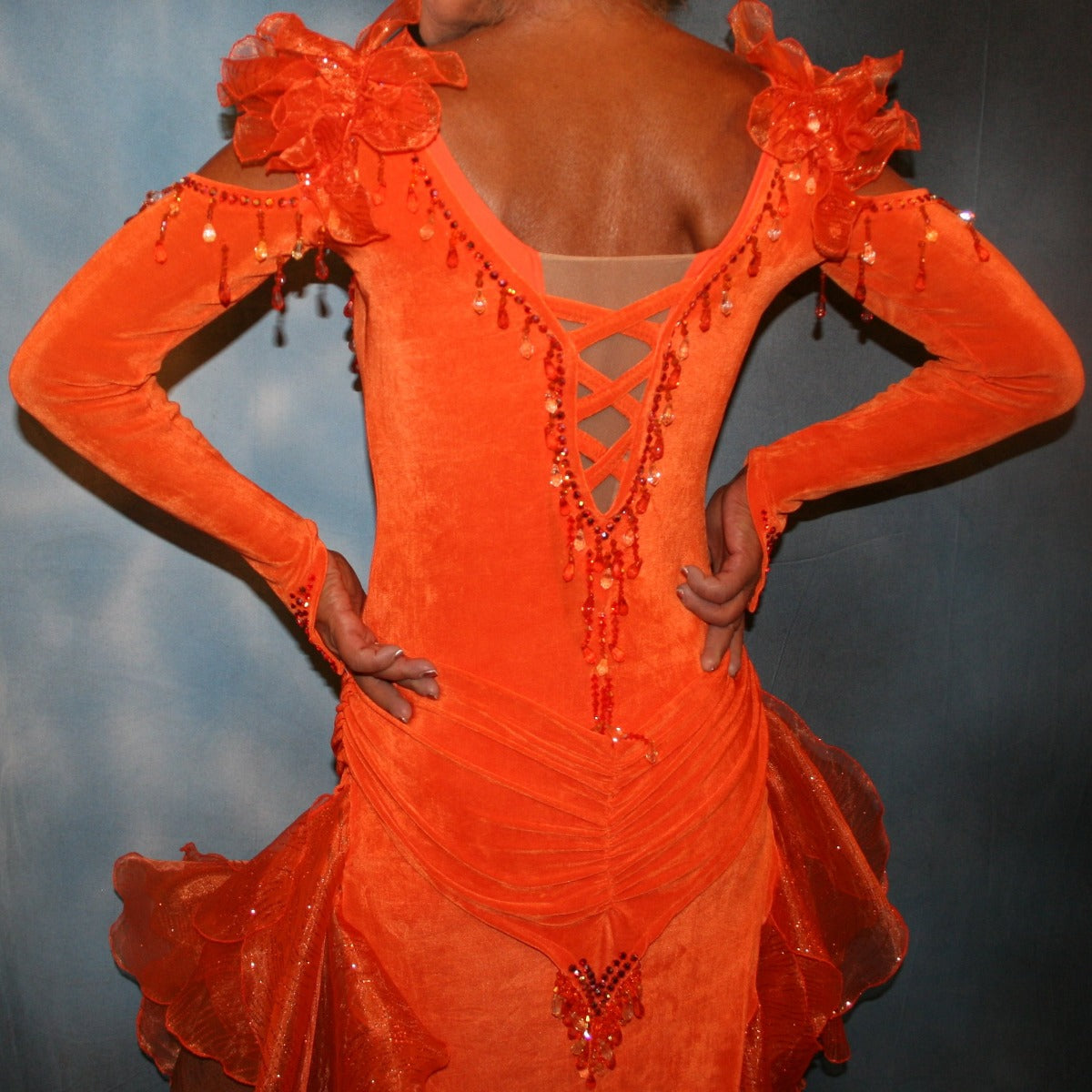 Crystal's Creations close up back view of Orange Latin/rhythm dress was created in luxurious solid slinky with orange glitter organza flounces, embellished with orange Swarovski stonework & hand beading.