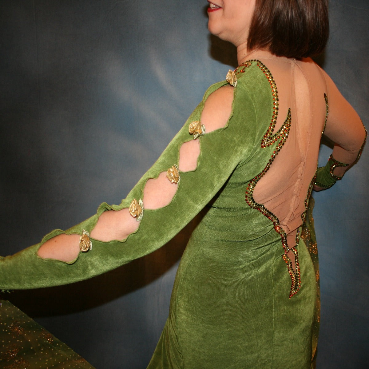 Crystal's Creations side close up view of Green ballroom dress created of luxurious olive green solid slinky on nude illusion base with glitter chiffon print flounces of olive greens & gold… embellished with olivine, jonquil & peach Swarovski rhinestones.