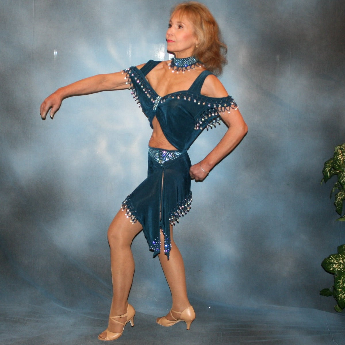 Crystal's Creations side view of 2 piece blue Latin/rhythm dance dress was created of deep sea blue luxurious solid slinky with cascades of hand beaded fringe plus light sapphire Swarovski rhinestone work. The Latin dance skirt has built in tights.