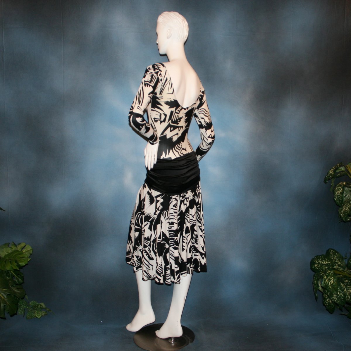 left side view of Black & white tropical print lycra dress with solid black hip sash. Bodysuit base, so a great dress for Latin/rhythm dance practice or ballroom teachers!