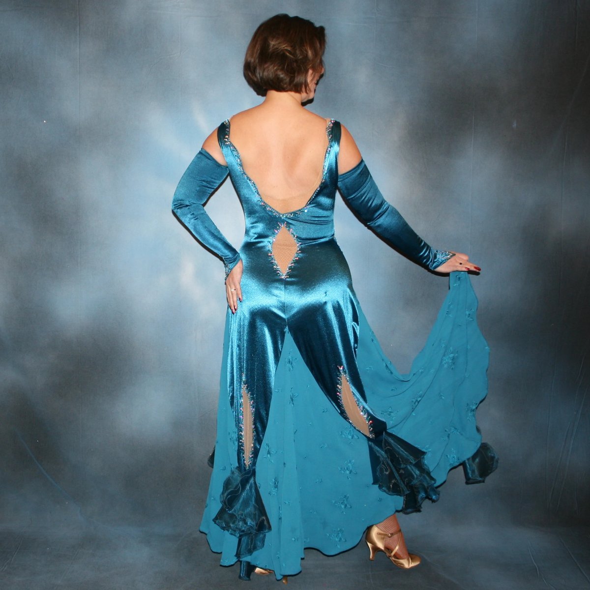 Crystal's Creations back view of Blue ballroom dance dress was created in luxurious deep sea blue stretch satin with deep sea blue crepe chiffon embroidered insets, organza flounces…nude illusion cutout detailing…embellished with CAB & blue zircon Ab Swarovski stonework.