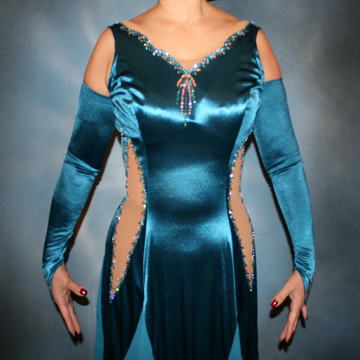 Crystal's Creations close up view of Blue ballroom dance dress was created in luxurious deep sea blue stretch satin with deep sea blue crepe chiffon embroidered insets, organza flounces…nude illusion cutout detailing…embellished with CAB & blue zircon Ab Swarovski stonework.