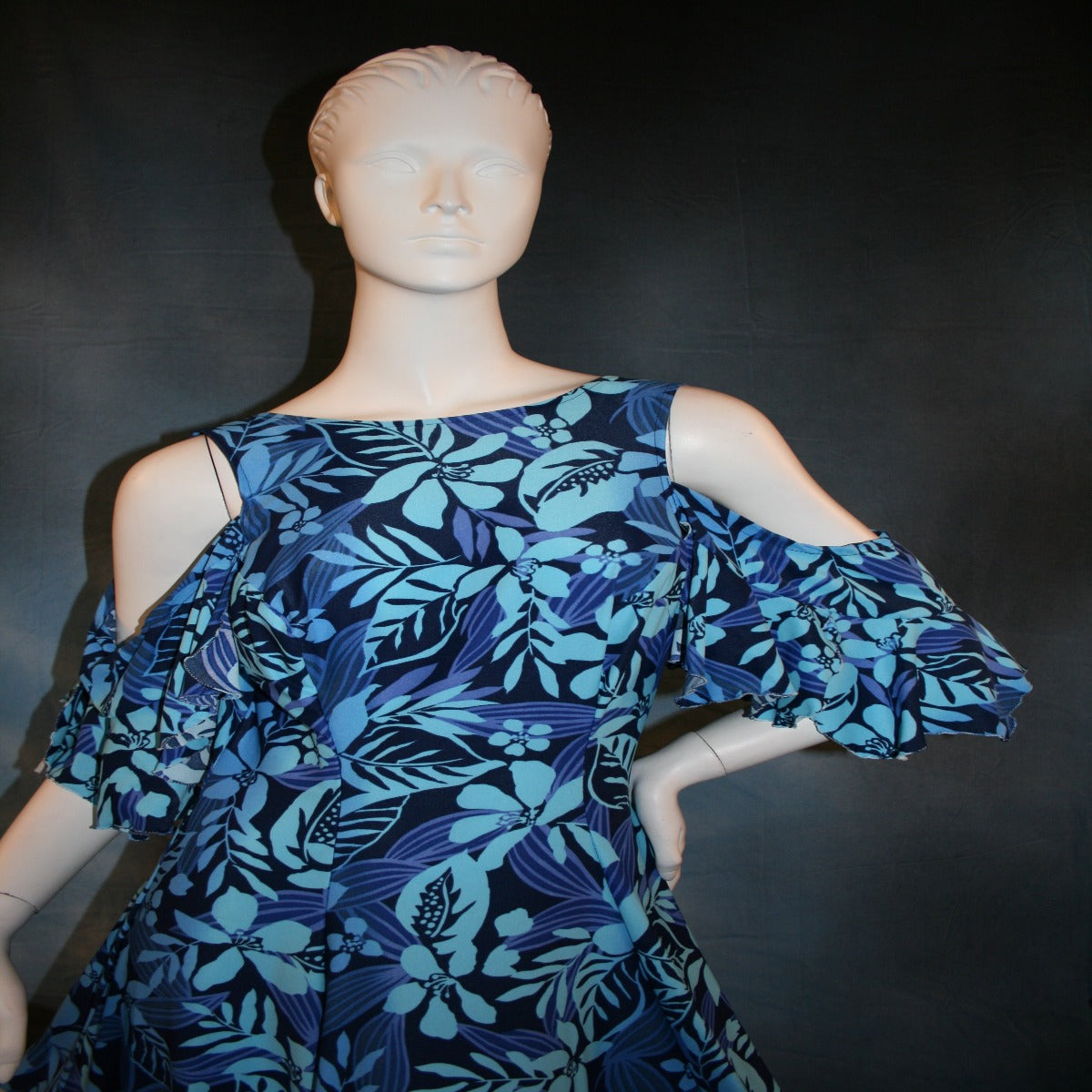 close top view of Blue social ballroom dress created in tropical blue print lycra with oodles of flounces, draping cold shoulder sleeves with flounces.